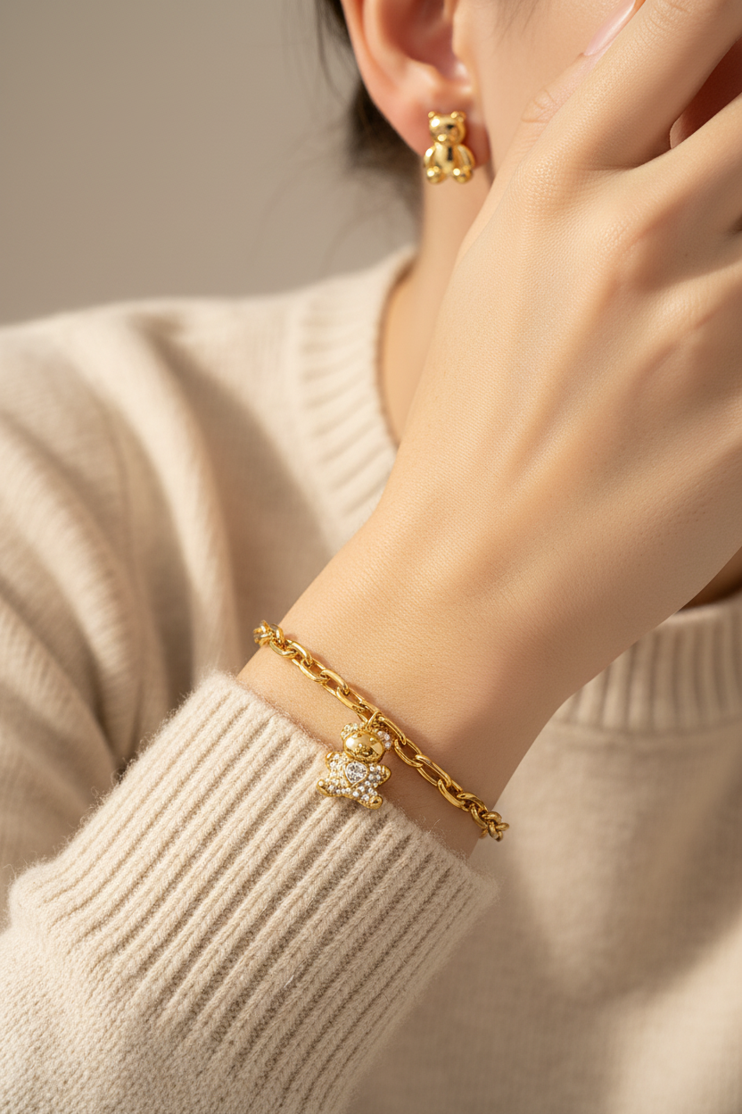 Model wearing gold teddy bear stud earrings and pearl CZ teddy bear bracelet