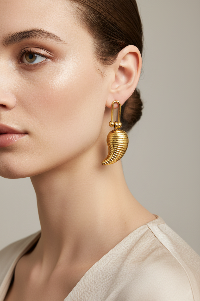 Model wearing ribbed gold chili pepper drop earrings