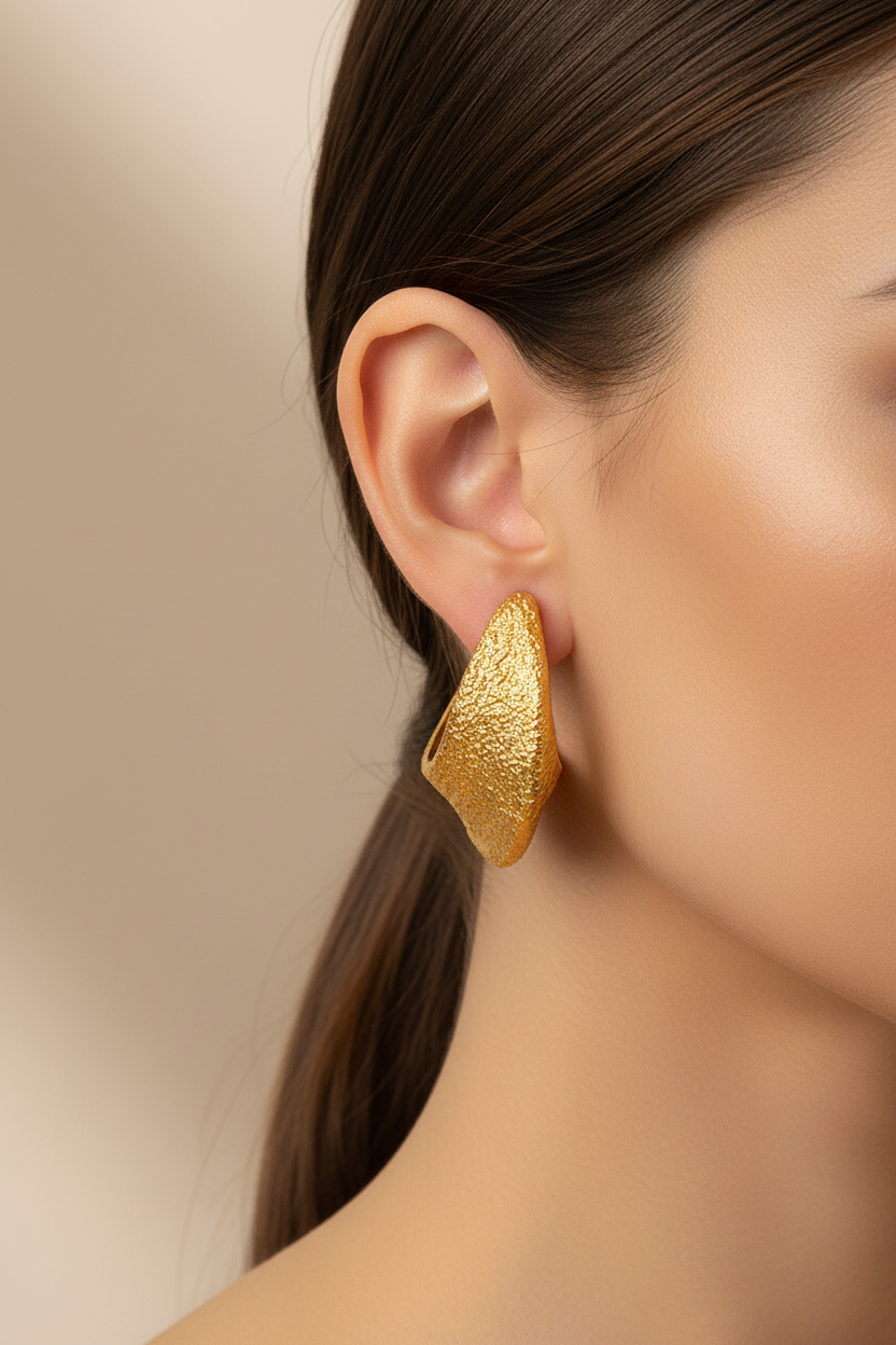 Model wearing gold textured C-hoop earrings