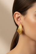 Model wearing gold textured C-hoop earrings