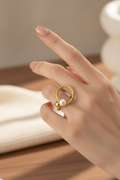 Model wearing gold twisted rope pearl open band ring